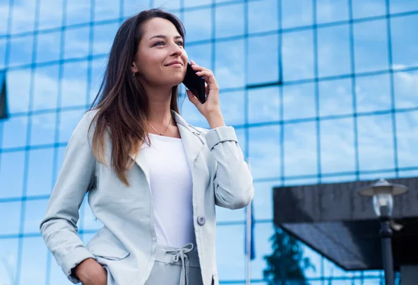 Chica hablar por teléfono al aire libre. hermosa dama con ropa elegante. belleza femenina y moda. mujer de negocios con teléfono inteligente. comunicación empresarial. mujer confiada en traje elegante formal. Sé feliz. — Foto de Stock