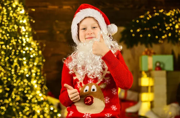 Tú eres el siguiente. vacaciones de Navidad de invierno. comprar regalos y regalos. compras de temporada. niño pequeño listo para la fiesta de año nuevo. niño feliz celebrar la Navidad en casa decorada. niño de santa en sombrero y suéter — Foto de Stock