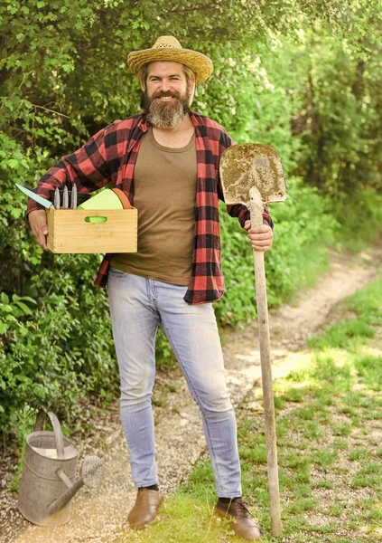 Caucasian farmer countryside nature background. Tools for gardening. Gardener agricultural worker with garden tools. Garden tools every gardener should have. Look after them and store them carefully