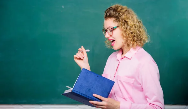 Woman school teacher in front of chalkboard. Passionate about knowledge. Pedagogue hold book and explaining information. Education concept. Teacher explain hard topic. Teacher best friend of learners