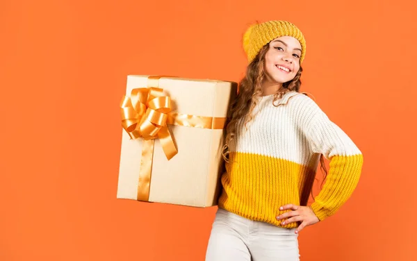온라인에서 선물을 찾아보 세요. 선물 배달 서비스. 장보기. 크리스마스가 왔네. 겨울 연휴 놀람. 모자랑 스웨터입은 여자. 아이는 현재의 주황색 배경을 가지고 있습니다. 해피 신년 2020 년 — 스톡 사진