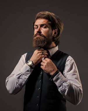 Papyonu düzeltiyorum. Takım elbiseli başarılı bir adam. İş adamı takım elbise giyer. Resmi ofis hayatı. Ciddi sakallı adam. Pahalı takım elbiseli yakışıklı, başarılı adam. Tişörtlü, kol saati olan.