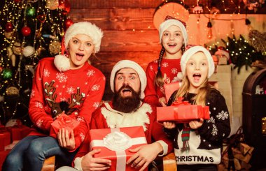 İyi tatiller. Ebeveynler ve çocuklar Noel hediyelerini açıyor. Noel Baba ve anne küçük kızları Noel ağacı geçmişi. Noel geleneği. Aile bağları aktiviteleri. Noel neşesi