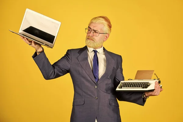 Compre um novo gadget moderno. Dispositivo útil. Moderno em vez desatualizado. Connoisseur de valores vintage. Máquina de escrever contra o portátil. O empresário usa a tecnologia moderna. Homem tingido barba cabelo amarelo fundo — Fotografia de Stock