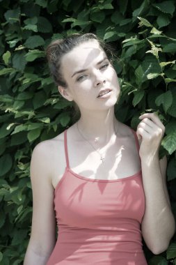 Genç bayan, yeşil yaz parkının arka planında yeşil yapraklar. Güzel kız. taze yaz konsepti