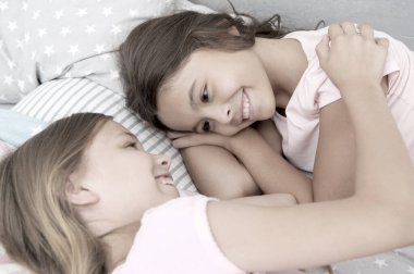 Kız kardeşime biraz sevgi gösteriyorum. Sevimli kız, kız kardeşini sevgiyle kucaklıyor. Küçük çocuklar arasındaki saf sevgi anı. Aile sevgisi