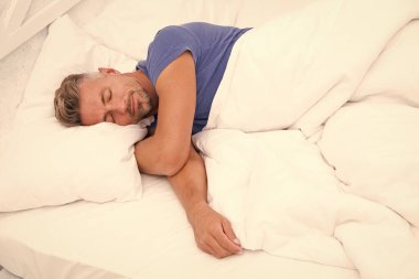 Evde yumuşak yastıklarla yatakta yatan seksi adam. Mükemmel bir sabah. Bahşişler daha iyi uyuyor. Erkek sağlığı. Evde iyi vakit geçiriyorum. Yatak odasında dinleniyor. hayal kuran erkek. Gündüz uyuyor. Yeni bir günün sabahı