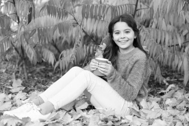 Kahve fincanı seni sıcak hissettirebilir. Küçük çocuk elinde bir fincan sıcak kahve tutuyor. Küçük kız sonbahar manzarasında kahve içmekten zevk alır. - Günaydın. Kahvaltıda. Kendini iyi hissetmen için tek gereken şey kahve.