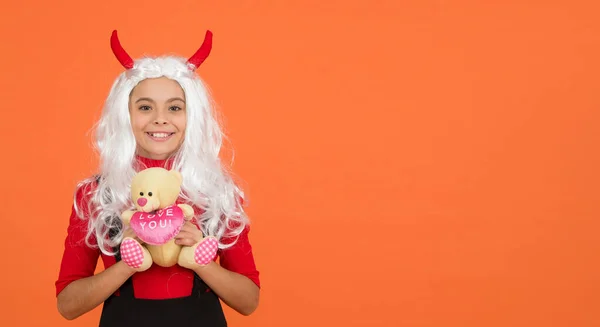 子供の頃。ハッピーハロウィーンの悪魔の女の子。小さな角の10代の子供。陽気な子はテディベアのおもちゃを持ってる。おもちゃ屋で買い物。カーニバルコスチュームパーティー。トリックか治療か。祝日を祝うんだ。コピースペース — ストック写真