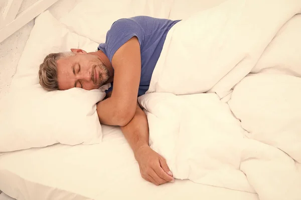 Hombre sexy acostado en la cama con almohadas suaves en casa. Mañana perfecta. Consejos para dormir mejor. salud masculina. Disfrutando del tiempo en casa. Relajante en el dormitorio. Un hombre soñando despierto. Día durmiendo. Mañana de un nuevo día —  Fotos de Stock