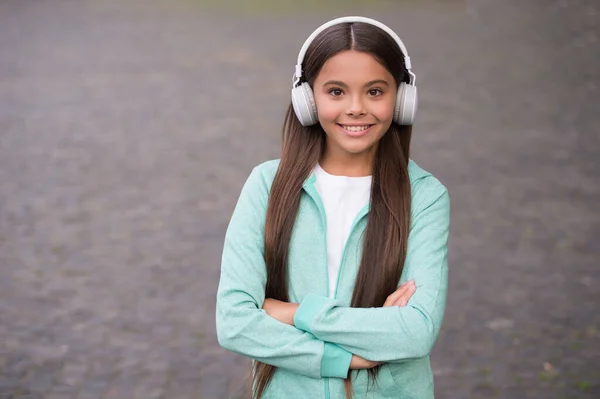 Criança alegre usar fones de ouvido com música música ao ar livre apreciando melodia, eLearning educação — Fotografia de Stock