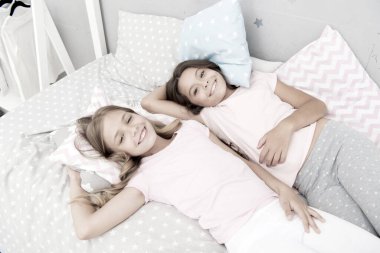 Pijama partisi ve arkadaşlık. Kız kardeşler yatak odasında dinlenen mutlu küçük çocuklar. Küçük kızların arkadaşlığı. Boş zaman ve eğlence. En iyi arkadaşımla eğleniyorum. Çocuklar neşeli, neşeli, birlikte eğleniyorlar.