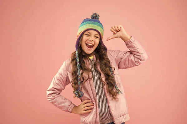 Ωραία μέρα. μικρό γυναικείο χειμωνιάτικο καπέλο. έτοιμοι για χειμερινή δραστηριότητα. χαρούμενο παιδικό ροζ φόντο. Φθινοπωρινό. Χαρούμενη παιδική ηλικία. Παιδική μόδα και ψώνια. μοντέρνο κορίτσι χαμογελάει. ζεστά ρούχα για την κρύα εποχή — Φωτογραφία Αρχείου
