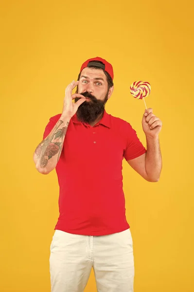 Hipster lolly snoep. Zelfgemaakte karamel snoep. Sweets verslaafd. Smaak naar kindertijd. Man eet lolly snoepjes. Plezier hebben met een zorgeloze man. Heerlijke lolly. Voedingswaarden. Calorieën en vitamine — Stockfoto