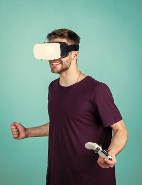 Sanal dünyamda. Dijital gelecek ve yenilik. Görsel gerçeklik. Adam kablosuz internet gözlüğü takıyor. Adam video oyunu oynuyor. Konsollu oyun oyuncusu. VR kulaklıklı bir erkek. Mutlu oyuncu modern teknolojiyi kullanır.