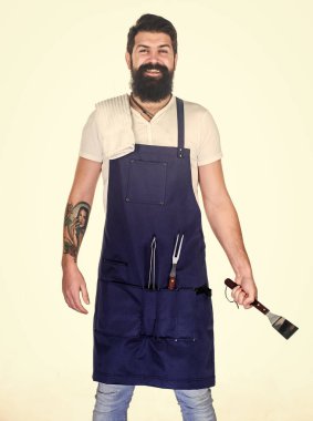 Biftek için eti nasıl seçersin? Profesyonel barbekü aleti. Sakallı hippi barbekü için önlük giyer. Kızartma ve ızgara yemek. Et pişiren bahşişler. Açık havada et kızartmak için aletler. Piknik ve barbekü