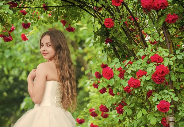 I am so excited. beauty and fashion. pretty kid smell rose flower. spring and summer nature. little girl in garden. child enjoy blossom in park. small angel for bride. cute lady. happy childhood — Stock Photo, Image