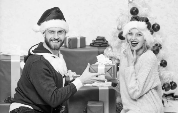 Presente ao amado. Casal apaixonado feliz desfrutar de Natal celebração do feriado com presentes. Amante casal abraço sorrindo ao desempacotar presente natal árvore fundo. Família preparou presentes de Natal — Fotografia de Stock