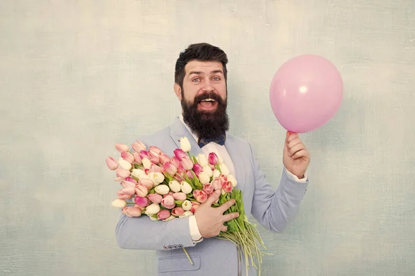 Ajoutez de la joie aux fêtes avec ce bouquet festif. Un barbu tient des tulipes et un ballon. Fête. Joyeuse Saint Valentin. Journée des femmes. Arrangement de fleurs de vacances. Rendre les vacances beaucoup plus spéciales — Photo