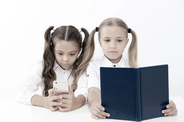 Conceito de leitura. A obter informações. Meninas lendo livro de papel e ebook no smartphone. A escolha certa — Fotografia de Stock