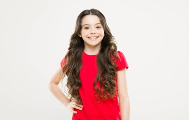 Küçük kız gülümsüyor. Uzun kıvırcık saçlı mutlu kız. moda ve güzellik. hippi çocuk. çocukluk mutluluğu. Kuaför salonu. Cilt bakımı ve doğal saç. Doğal güzellik. Küçük güzellik gülümsüyor