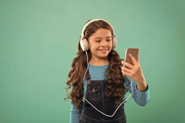 Rozmowa wideo. Mała dziewczynka ze smartfonem. Mała dziewczynka używa telefonu komórkowego. Dziecko uczy się nowych technologii. Ładny użytkownik technologii telefonu komórkowego. Oglądam wideo na urządzeniu mobilnym. Styl życia blogerki — Zdjęcie stockowe