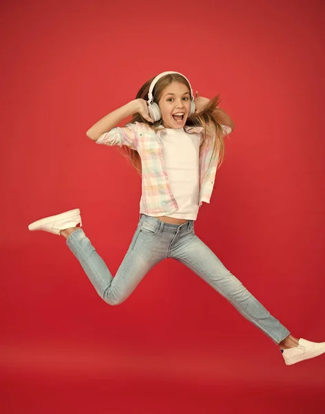 Salto a mezz'aria. Musica facile da ascoltare. Ragazzina che ascolta musica in cuffia. Ragazza ballerina. Felice bambina che balla. Bambino carino godendo di musica da ballo felice. La musica è felicità per lei — Foto Stock