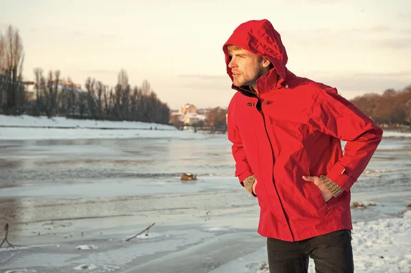 warm clothes for cold climate. weather forecast. human and nature. man walking snowy landscape in sunset. travel and expedition. man in red parka. winter male fashion. copy space. nice winter holiday