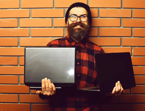 Bearded brutal caucasian hipster holding laptops — Stock Photo, Image