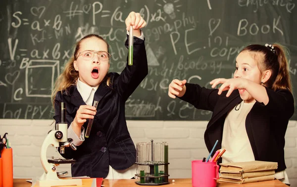 Concetto di esperimento educativo. Fare attenzione a eseguire la reazione chimica. Conoscenze di base di chimica. Le ragazze studiano chimica. Rendi interessante lo studio della chimica. Microscopio e provette sul tavolo — Foto Stock