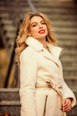 Sıcak palto giyen kız şehir arka planında. Rahat ve güzel hissetmek için sonbahar kıyafeti yap. Sonbahar kıyafeti. Makyajcı kadın şık kıyafetler giyer. Modern sıcak ve şık eko kürk giysisi