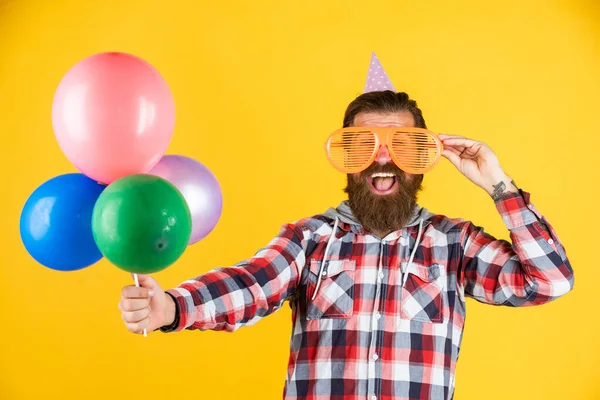 Jovens e despreocupados. Elementos de festa e objetos de férias. Divertimento multicolorido. melhor festa para a reforma. homem alegre com barba e bigode. hipster sorrindo com balão. Celebrando a festa feliz — Fotografia de Stock