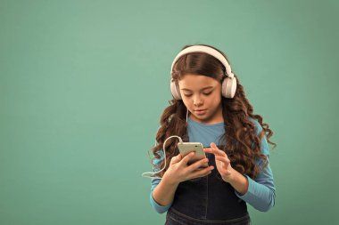 Liseli kız dijital cihaz kullanıyor. Çocuklar için sıradan moda. Uzun saçlı çocuk kulaklıkla müzik dinliyor. Küçük çocuk akıllı telefondan çalma listesi yapıyor. Küçük kız mp3 çalar kullanıyor. Modern hayatta okumak. Boşluğu kopyala