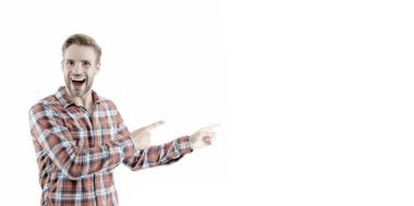 Dikkat çekici bir şey. Mutlu adam beyazları işaret ediyor. Parmakla işaret eden yakışıklı adam. İşaret parmağı işaret ediyor. Reklam için işaret. Tanıtım için bilgi, kopyalama alanı