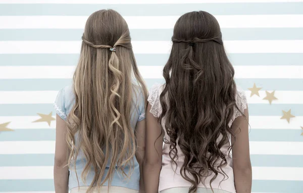 Ragazze bambini lunghi capelli ricci vista posteriore. Trattare i capelli in modo corretto in base al tipo. Applicare maschera balsamo dopo il lavaggio e spruzzare olio prima di styling riccioli. Consigli per parrucchieri. Acconciature facili ogni giorno — Foto Stock