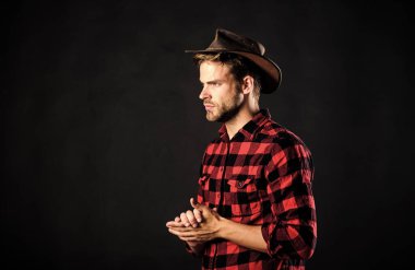 Cowboy life came to be highly romanticized. Masculinity and brutality concept. Adopt cowboy mannerisms as a fashion pose. Man unshaven cowboy black background. Archetypal image of Americans abroad clipart