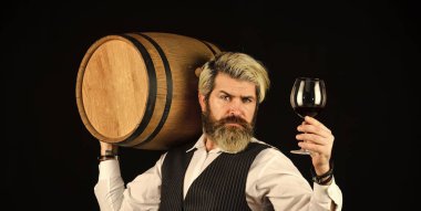 Sommelier iş başında. Fıçılı şık takım elbiseli sakallı iş adamı. Sommelier 'in pahalı bir içeceği var. Zarif garson şarap taşıyor. Şarap mahzeninde çalışıyorum. Şarap barı ya da şaraphane. şarap degukasyonu