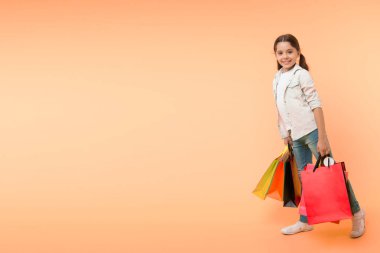 Alışveriş günü. Mutlu çocukla alışveriş günü. Alışveriş gününde gülümseyen küçük kız. Alışveriş gününden sonra paketli kız, boşluğu kopyala.