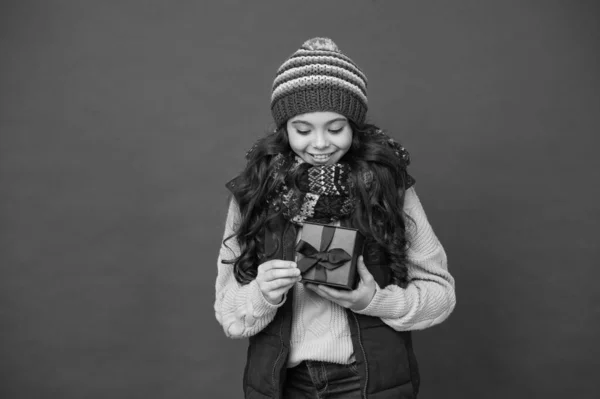 Winkeltijd. Mooie aankoop. Meisje met nieuwjaarskado. Fijne wintervakantie. Meisje gebreide muts en sjaal. Vrolijk kerstfeest. Kerstmis feeststemming. wintershoppen. kindergeluk — Stockfoto