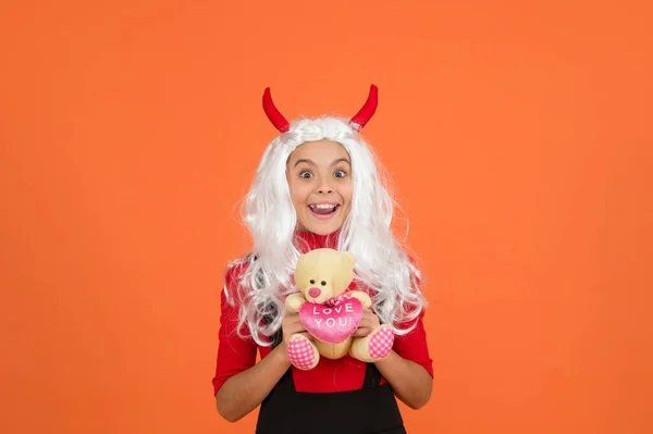 Thank you. smiling child in devil horns with teddy bear toy. kid has white hair wig. childhood happiness. teen girl ready to celebrate costume party. funny red imp horns. happy halloween — Stock Photo, Image