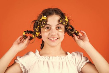 Şuna bak. Saç bigudileriyle poz ver. Kuaförde oynayan, saç bigudili mutlu kız. Çocuklar için saç stili yapmak için kolay ipuçları. Kuaför aletleri ve saç aksesuarları. Yüzü yamalı çocuk