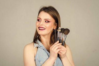 Saf güzellik. Moda makyaj suratı. Cinsellik. Cilt kozmetiği. Güzellik kuaförü salonu. Ruj ve göz farı. Uzun saçlı, tarz sahibi şehvetli bir kadın. Profesyonel makyaj fırçası olan seksi bir kadın.