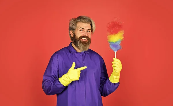 Cleaning service. Housekeeping duties. Cleaning apartment. Man use pp duster. Dust allergy. Polypropylene duster. Hipster holding cleaning tool. Cleaning home concept. Small colorful duster broom