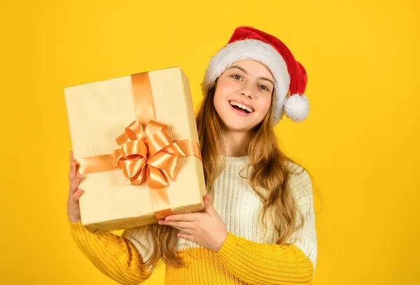 Vánoční nakupování online. čas na slevu. Usmívající se dítě drží krok. dárky a dárky od Santa Clause. malá dívka Santa na žlutém pozadí. oslava vánočního večírku. šťastný nový rok — Stock fotografie