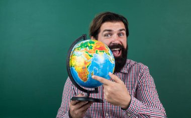 Kareli tişörtlü neşeli sakallı adam elinde coğrafya, coğrafya okulu eğitimi