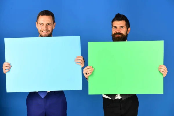 Hombres con barba sostienen tableros sobre fondo azul. — Foto de Stock