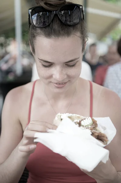 Šťastný preatty dívka nebo žena jíst sendvič gyros. — Stock fotografie