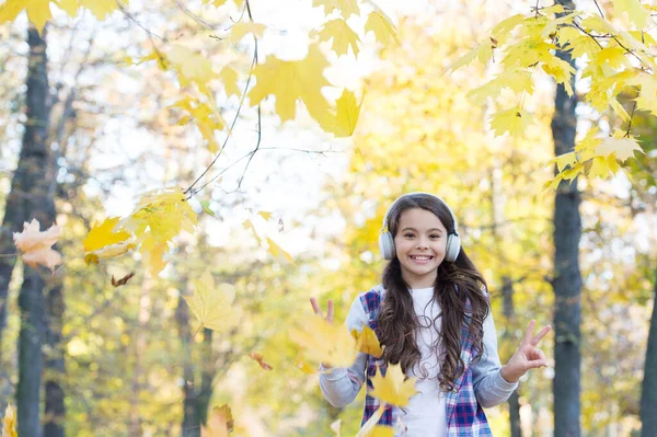 Moda autunno bambino. ispirazione. infanzia felice. Torniamo a scuola. ragazza con foglie nel parco. caduta bellezza nella foresta. godere della musica in cuffia. istruzione online e e-learning. Pronti per nuove avventure — Foto Stock