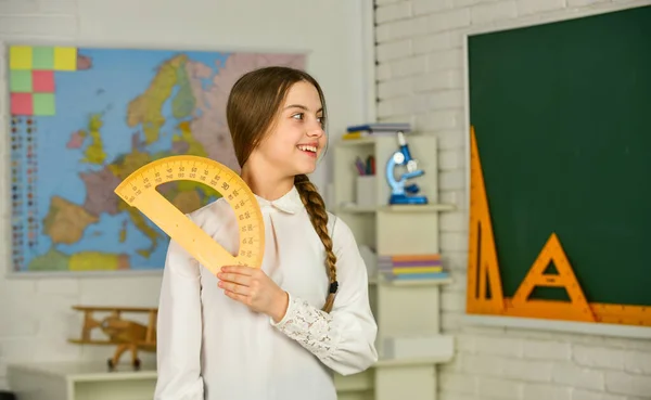 Schattig klein schoolmeisje met geometrisch gereedschap voor wiskunde. Wiskunde of wiskunde van de basisschool. Wetenschap en Technologie. Wiskunde is belangrijk. Klein kind met heerser voor wiskundeles — Stockfoto