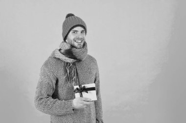 Noel hediyesi. Adam kışlık şapka takıyor. Mutlu Noeller ve mutlu yıllar. Kış tatili Şapka takan adam. Olumlu duygular. Yakışıklı adam kış tatilini mavi arka planda kutluyor.